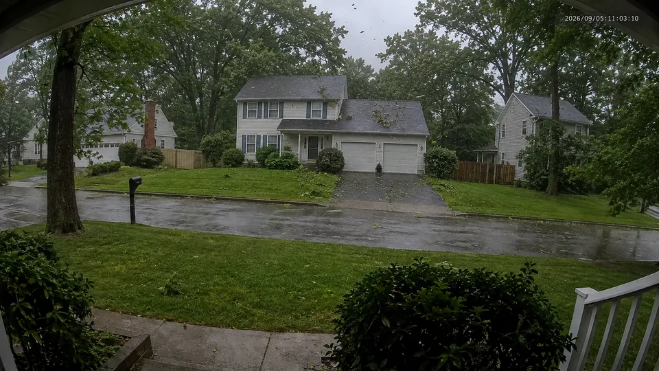 Doorbell camera view of wind and debris during a storm